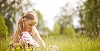 Small girl collecting flowers on a summery meadow