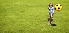 Boy kicking a ball on the field