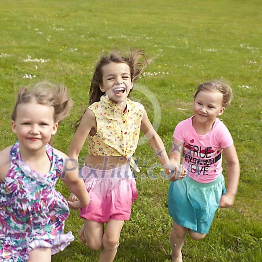 Three girls running on the grass Three girls running on the grass