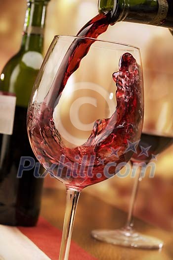 Red wine being poured to the glass Red wine being poured to the glass
