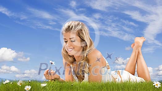Woman on the grass enjoying daisies Woman on the grass enjoying daisies