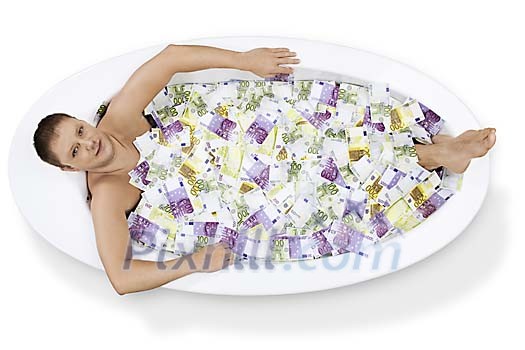 Isolated bath tub with money with a man soaking in it Isolated bath tub with money with a man soaking in it
