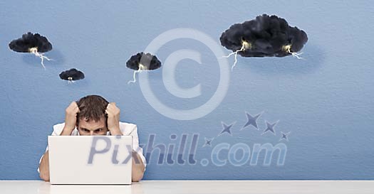 Man concentrating behind laptop having thunder-clouds hanging over his head Man concentrating behind laptop having thunder-clouds hanging over his head