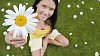 Girl handing a daisy up to camera