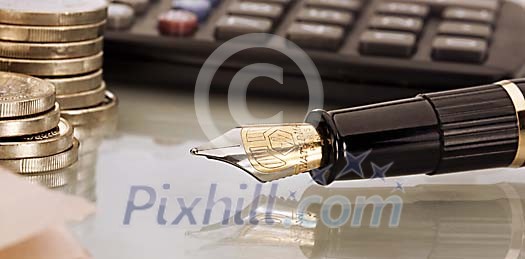 Shallow focus close-up of pen, coins and keyboard on a table Shallow focus close-up of pen, coins and keyboard on a table