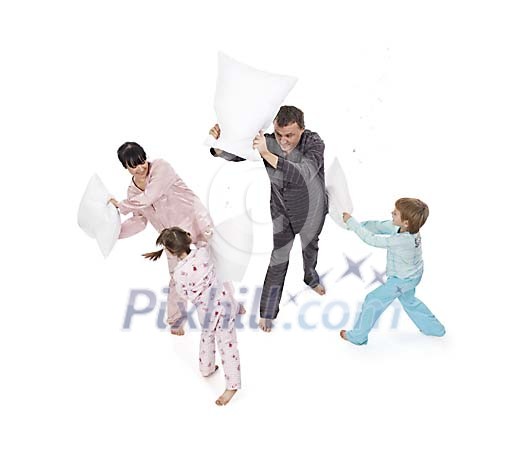 Father, mother, daughter and son playing pillow fight in white space Father, mother, daughter and son playing pillow fight in white space