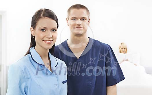 Two nurses and patient in a light hospital room