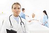 Female doctor, nurses and patient in a light hospital room