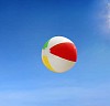 Beach ball flying against blue sky