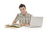 Teenage boy behind study books and laptop