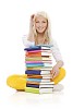 Teenage girl sitting behind a pile of books