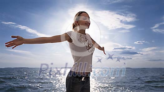 Young woman spreading her arms by the sea Young woman spreading her arms by the sea