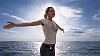 Young woman spreading her arms by the sea