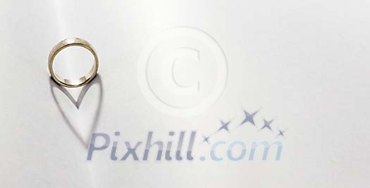 Wedding ring casting a heart shadow on table Wedding ring casting a heart shadow on table