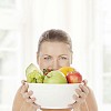 Woman holding a bowl full of fruits