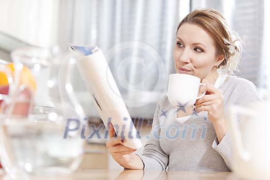 Woman reading magazine in the kitchen Woman reading magazine in the kitchen