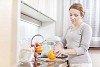 Woman in the kitchen cutting orange