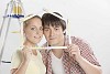 Couple looking through folding ruler shaped as a house