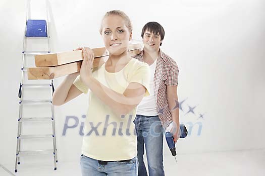 Couple carrying pieces of timber Couple carrying pieces of timber