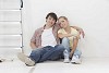 Couple sitting on the floor next to a ladder