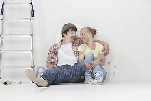 Couple sitting on the floor smiling Couple sitting on the floor smiling