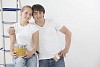 Couple posing with paint can and a brush