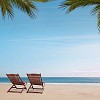 Two deckchairs on an empty beach