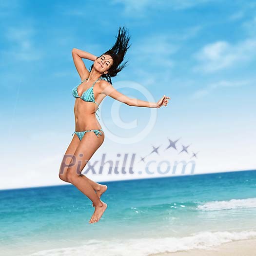 Woman jumping in the air with sea at the background Woman jumping in the air with sea at the background