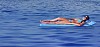 Woman sun tanning on a swimming matress on the sea