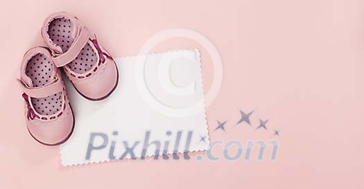 White empty card with baby girls shoes White empty card with baby girls shoes