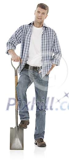 20-30 year old man standing relaxed with a shovel, hand made clipping path included 20-30 year old man standing relaxed with a shovel, hand made clipping path included