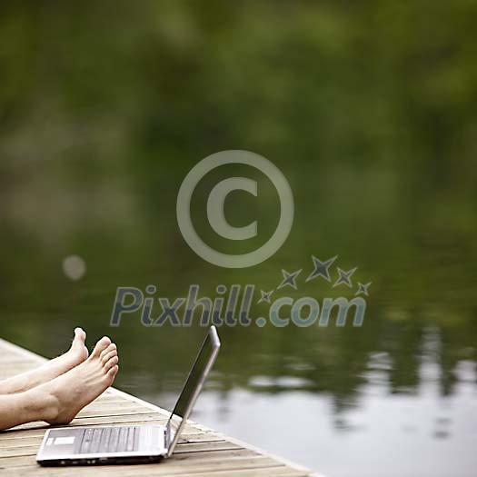 Male resting next to his laptop on dock Male resting next to his laptop on dock