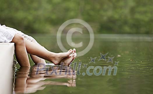 Male and female feet touching each other on the dock Male and female feet touching each other on the dock