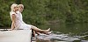 Male and female sitting realxing on the dock near the lake