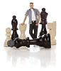 Clipped image of a man standing between oversized chess pieces