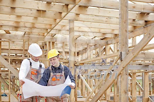 Constructors at a construction site looking at the plan