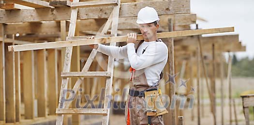Constuction worker carrying timber Constuction worker carrying timber