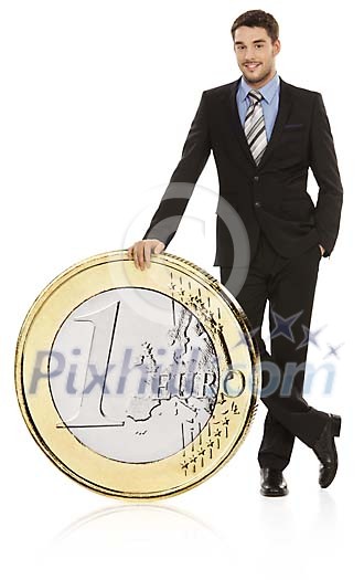 Business man standing next to oversized euro coin Business man standing next to oversized euro coin