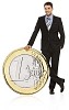 Business man standing next to oversized euro coin