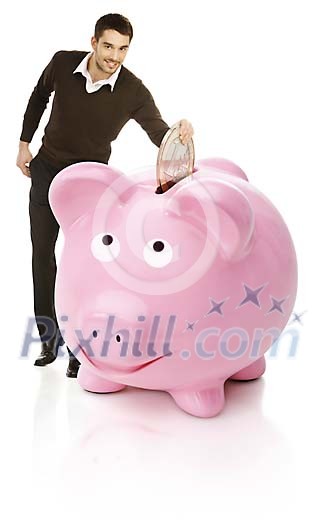 Man puts oversized euro coin in to a giant piggybank Man puts oversized euro coin in to a giant piggybank