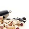 Red wine bottle, corkscrew and corks in shallow focus