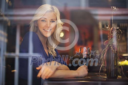 Woman smiling through the wine bar window Woman smiling through the wine bar window