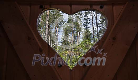Heart opening in toilet door showing forest Heart opening in toilet door showing forest