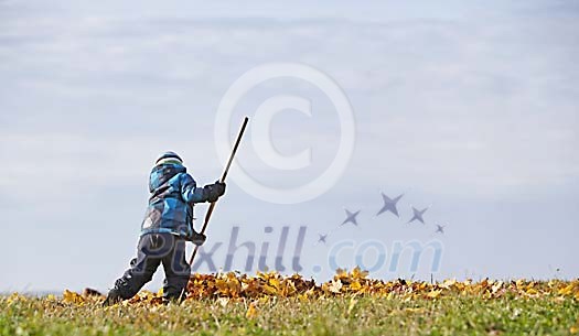 Boy is raking the autumn leaves Boy is raking the autumn leaves
