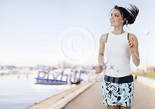 Woman running outside along the shoreline Woman running outside along the shoreline