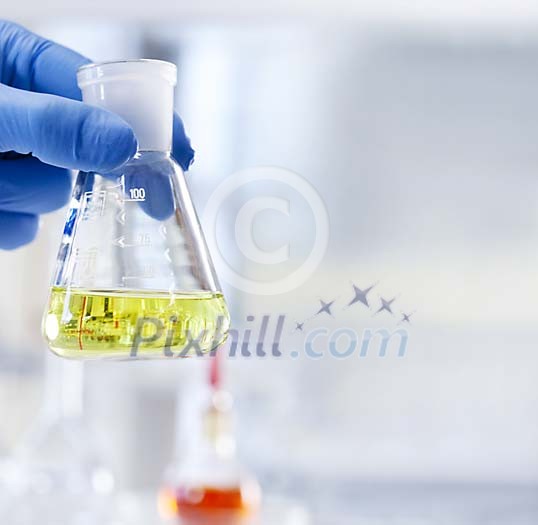 Hand holding a measuring glass Hand holding a measuring glass