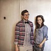 Smiling man and a woman standing by the door