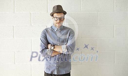 Serious looking man standing by the wall Serious looking man standing by the wall