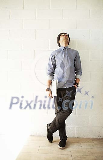 Man standing by the wall, looking up Man standing by the wall, looking up