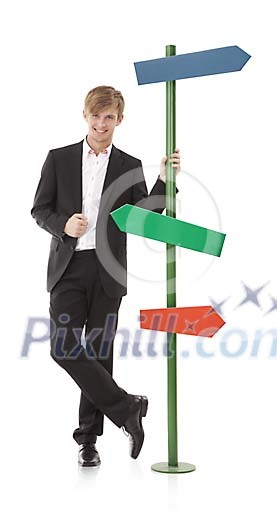 Isolated man standing next to a direction post Isolated man standing next to a direction post